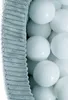 A close-up view of white balls in a ball pit, with a textured gray fabric border on the left side. Produktbild-Vorschau