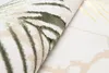 A close-up view of a rug with a leaf-like pattern. Produktbild-Vorschau