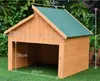 A wooden dog house with dimensions marked on it, placed on a grassy lawn. Voir les images du produit