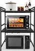 A black metal kitchen shelf unit holding a microwave oven on the bottom shelf and a toaster oven on the middle shelf. The top shelf holds a slow cooker, two jars, and two bottles. Náhled obrázku produktu