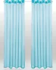 Two turquoise sheer curtains hanging on a curtain rod against a light gray background.