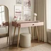 A pink console table with an open drawer, a stool, and a mirror in a room with artwork and curtains. Produktbild-Vorschau