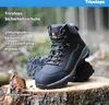 A pair of black work boots are displayed on a tree stump in a forest setting. Produktbild-Vorschau