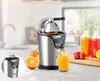 A juicer is shown in action, with juice being poured into a glass, surrounded by oranges and bottles of juice. Náhled obrázku produktu