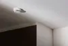 A smoke detector is mounted on a white ceiling. Voir les images du produit