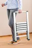 A person is holding a folded aluminum step stool. Náhled obrázku produktu