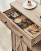 A close-up, angled view of an open wooden drawer filled with various kitchen items, including spice jars, a woven basket, and packaged goods. Náhled obrázku produktu