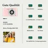 A pink digital camera is shown on the left, with feature icons and descriptions on the right. A woman is also pictured holding a camera. Podgląd zdjęcia produktu