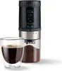 A black and silver electric coffee grinder with a glass collection container is shown next to a glass of coffee. Produktbild-Vorschau