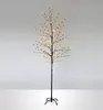 A decorative LED tree with warm white lights on a black stand against a light gray and white background. Voir les images du produit