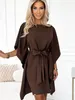A woman wearing a brown dress indoors. Produktbild-Vorschau