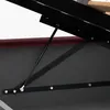 A close-up view of a bed frame mechanism, showing a gas strut and metal supports. Produktbild-Vorschau