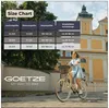 A woman riding a bicycle in front of a building. Produktbild-Vorschau