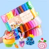 A hand holding a package of colorful modeling clay sticks, with several finished clay creations in the foreground. Náhled obrázku produktu