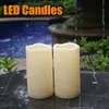 Two LED candles are placed on a marble table in front of a fountain and pool. Náhled obrázku produktu