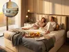 A couple enjoying breakfast in bed in a modern bedroom. Produktbild-Vorschau