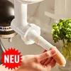 A person is holding a sausage stuffer attachment for a KitchenAid mixer, with a bunch of parsley in the background. Anteprima dell’immagine prodotto
