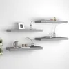 Four gray floating shelves are mounted on a white wall, each displaying various decorative items and books. Náhled obrázku produktu