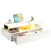 A white modern coffee table with LED lighting, drawers, and various items on top. Produktbild-Vorschau
