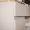 A close-up view of a modern desk with drawers and a metallic trim. Produktbild-Vorschau