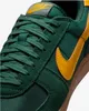 A close-up view of the front of a green and yellow Nike sneaker. Podgląd zdjęcia produktu
