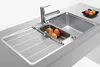 A stainless steel kitchen sink with a faucet and a small bowl of fruit. Produktbild-Vorschau