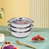 A stack of three stainless steel pots with glass lids, set on a table with a bowl of fruit and a fork. Náhľad obrázku produktu