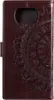 A close-up view of a brown leather flip case for a smartphone, featuring an embossed mandala pattern. Produktbild-Vorschau