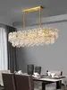 A rectangular chandelier with crystal accents hangs above a dining table set for a meal. Anteprima dell’immagine prodotto