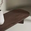 A close-up shot of a wooden coffee table with a vase and dried flowers. Produktbild-Vorschau