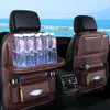 Car interior with a brown leather seat organizer attached to the back of a car seat, filled with water bottles and other items. Anteprima dell’immagine prodotto