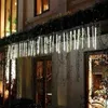 Icicle lights are hung along the top of a building's exterior, with vines hanging down in front of them. Náhľad obrázku produktu