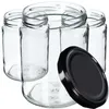 A group of empty glass jars with a black lid in the foreground. Podgląd zdjęcia produktu