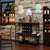A bar cart with wine bottles and glasses, set up in a home or commercial space with a window and brick wall. Podgląd zdjęcia produktu