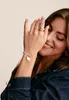 A woman is wearing a bracelet and ring, with her hand covering part of her face. Produktbild-Vorschau
