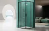 A modern shower enclosure with black frames and glass doors is showcased in a minimalist bathroom setting, with a glimpse of a living area in the background. Produktbild-Vorschau