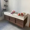 A bathroom vanity with a double sink and flowers on top, placed against a wall. Anteprima dell’immagine prodotto
