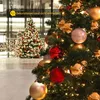 A close-up of a decorated Christmas tree with a blurred background of another Christmas tree and lights. Produktbild-Vorschau