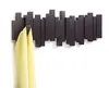 A dark brown coat rack with five movable hooks is mounted on a white wall. A yellow scarf is hanging on one of the hooks. Náhľad obrázku produktu