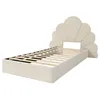 A beige upholstered bed frame with a scalloped headboard and wooden slats for a mattress. Voir les images du produit