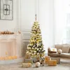 A decorated Christmas tree with presents underneath, in a living room setting with a fireplace and sofa. Náhľad obrázku produktu
