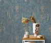 A close-up shot of a vase with dried flowers and a small plant on a wooden table against a textured blue and gold wallpaper background. Náhľad obrázku produktu