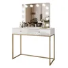 A white high-gloss vanity table with gold legs and a mirror with lights. Produktbild-Vorschau