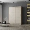 A modern bedroom or living room with a large sliding door wardrobe, a coffee table with a vase of flowers, and a bookshelf in the background. Voir les images du produit
