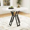 A round dining table with a marble-look top and black metal legs, set on a patterned rug in a well-lit room. Produktbild-Vorschau