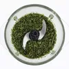 A top-down view of chopped green herbs in a glass food processor bowl with blades. Produktbild-Vorschau
