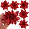 A hand holding a red glitter poinsettia decoration. Produktbild-Vorschau
