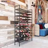 A wine rack filled with bottles in a room with a wooden wall and a blue sofa. Náhľad obrázku produktu