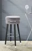 A bar stool is shown in a modern setting with a tiled wall and wooden floor. Náhľad obrázku produktu