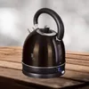 A black electric kettle sits on a wooden surface. Náhled obrázku produktu